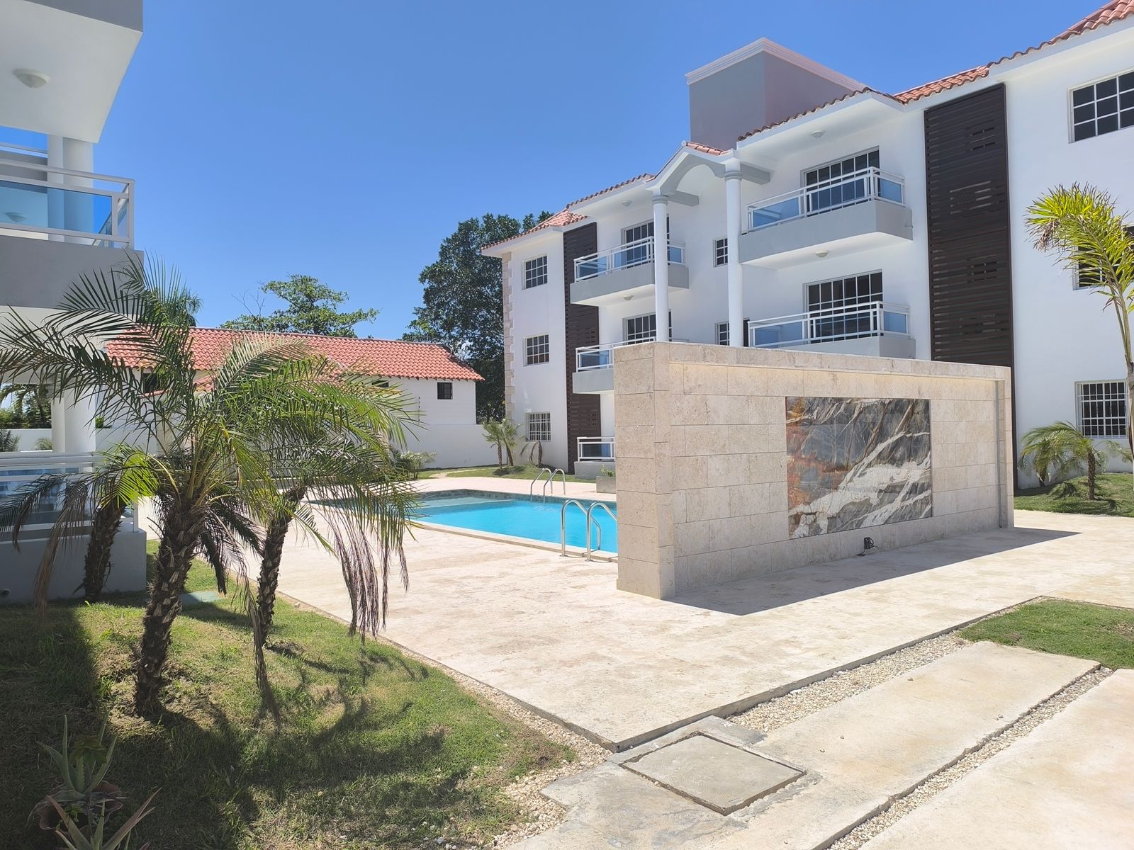 Área común con piscina y jardines del complejo Cana Esmeralda